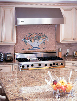 Beautiful backsplash of fruit bowl in mosaic stone above kitchen cooktop.